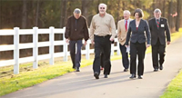 group of men and women walking along a greenway path
