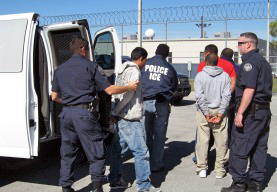 ICE agents escort three of the 95 arrested individuals towards incarceration