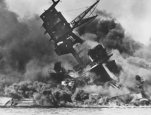 Shattered by a direct hit, the USS Arizona burns and sinks, December 7, 1941.