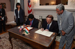 Dr. Elias A. Zerhouni, director, National Institutes of Health (seated left) and Dr. Maharaj K. Bhan, secretary, Department of Biotechnology (DBT), India (seated right) sign the Statement of Intent for the Indo-U.S. Collaboration on Expansion of Vision Research, August 24, 2005, Lawton Chiles International House, National Institutes of Health (NIH) campus, Bethesda, Maryland.  Tina Chung, John E. Fogarty International Center, NIH (left) and Dr. Kamal K. Dwivedi, counsellor for science and technology, Embassy of India (right) look on.