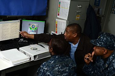 Mr. Dan Harrington (center) and ITCS Landell Rhodes (right) of Navy Cyber Forces (CyberFor) Cyber Security Inspection and Certification Program (CSICP) Stage II Training and Assessment Visit (TAV) Team review Cyber Security Workforce instructions and certification requirements with ITC Kadesha Perry (left) during a recent TAV on board USS GEORGE H W BUSH (CVN 73).  U.S. Navy photo by Mass Communication Specialist 2nd Class Timothy Walter (Released)  130122-N-FU443-022