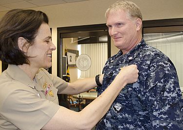 Rear Admiral Gretchen Herbert, Commander, Navy Cyber Forces, pins the Information Dominance Warfare Officer (IDWO) pin on Commander Allen M. Williams, Afloat Unit Level Training Officer, N7 (Training and Readiness Department) for Navy Cyber Forces.  The IDWO pin signifies Williams' milestone accomplishment of earning the Navy's newest warfare pin. Herbert began the ceremony by announcing that it was a historic moment, recounting what Deputy Chief of Naval Operations for Information Dominance (N2/N6), Vice Admiral Kendall L. Card, said 14 months ago when Williams requested to enroll in the IDWO program. 