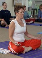 A woman practices a meditative yoga pose.