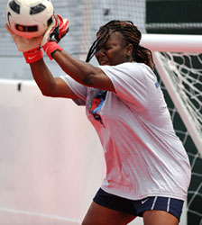 Photograph of a young goalie intercepting a soccer ball.