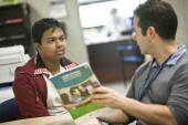 Two men reading pamphlet on Federal Student Aid