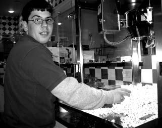 A young man in the MY TURN job program serves up popcorn at a concession stand.