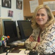 NIDA Communications Director, Carol Krause, sitting at her desk