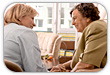 Middle Aged Woman and Elderly Woman Sitting Down and Talking