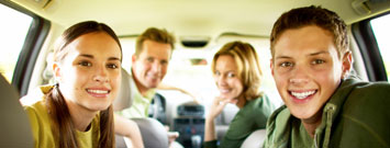 Photo: Teenage boy and girl with parents in a car