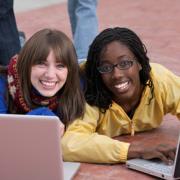 Two girls on their laptops.