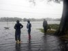 File of residents of the Colonial Place neighborhood survey flood waters as heavy rain from Hurricane Sandy floods the Lafayette River in Norfolk
