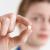 Here is an image of a girl holding a pill.