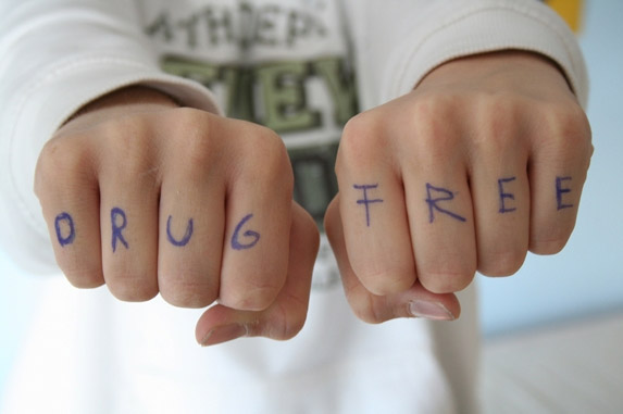 Two hands with the words "DRUG FREE" written on the knuckles.