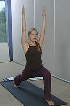 Yoga instructor demonstrates a warrior pose.