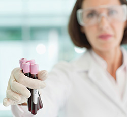 Female researcher holding vials of blood