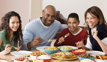 Photograph of a family eating a meal together.