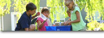 Four young children organizing recyclables