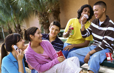 Young Native American people sit outdoors smiling.