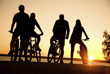 Family riding bicycles at sunset