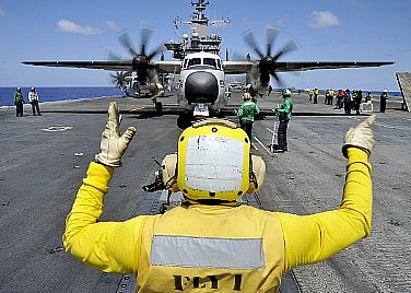 Aviation Boatswain's Mate (Handling) 2nd Class Dervin Gardner directs a C-2A Greyhound assigned to Carrier Airborne Early Warning Squadron (VAW) 120 onto a catapult on the flight deck of the aircraft carrier USS Harry S. Truman (CVN 75) as it prepares for takeoff. A C-2A Greyhound's primary mission is the transport of cargo, mail and passengers between carriers and shore bases. Harry S. Truman is underway conducting carrier qualifications.  U.S. Navy photo by Mass Communication Specialist Seaman Lorenzo J. Burleson (Released)  120905-N-PL185-257