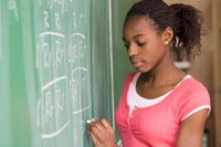 Photo: A girl writing on a chalkboard.