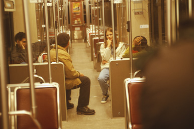 Young people riding a subway train at night.