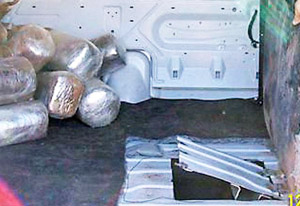 A trap door enabled smugglers to pass marijuana bundles from the tunnel's exit directly into the back of the cargo van.