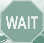 A stop sign reads WAIT.