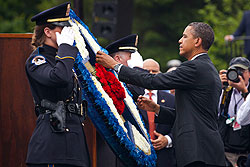 President Obama places a flower on a wreath at today’s memorial service.