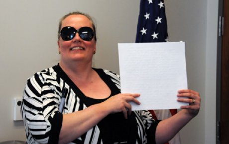 Dr. Gilson at her FFSB swearing-in ceremony.  She is holding a certificate printed in Braille.