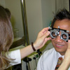 An eye care professional uses a trial frame and lens to determine a patient’s eyeglass prescription.