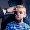 An eye care professional performs retinoscopy to determine the child’s refractive error (eyeglass prescription).