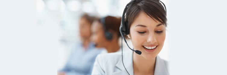 Photo of a woman smiling wearing a telephone headset.