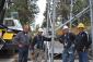 Construction crew members and Dave McGraw pose at the base of a tower