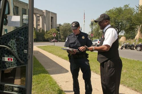 Photo of a strike force inspector checking a driver's hours-of-service.