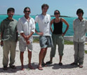 Photo of David Spiller, second from left, and other scientists posing on a beach in the Bahamas.