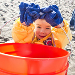 Child with a bucket, helping to clean up Ocean Beach at the California Coastal Cleanup Day.