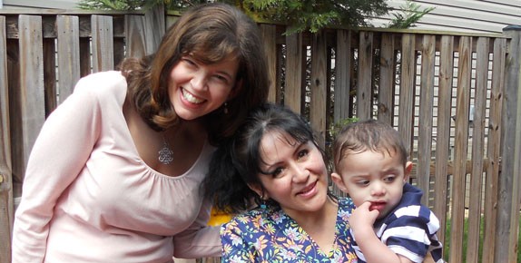 OCC Director Shannon Rudisill, smiling with a woman and her child