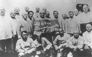 تحقیر زندانیان: زندانیان حزب سوسیال دموکرات (SPD) پلاكاردی را حمل می کنند که روی آن نوشته شده: "من از اختلاف طبقاتی آگاهم، رهبر حزب/حزب سوسیال دموکرات/رهبر حزب." اردوگاه کار اجباری داخائو، آلمان، بين سالهای 1933 و 1936.