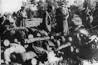 سوویت اہلکار کلوگا کیمپ میں لاشوں کے انبار کا معائنہ کرتے ہوئے۔