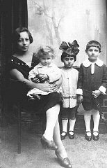 تین یہودی بچوں کی اپنی دیکھ بھال کرنے والی خاتون کے ساتھ جنگ سے پہلے کی ایک تصویر۔