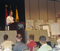 Photo of Kyle Hausmann-Stokes giving a Keynote Address.