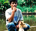 Image of a Mayangna hunter and his dog resting in a dugout canoe.