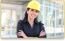 Una mujer con un casco amarillo está de pie frente a un edificio