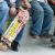 Three teens sitting and one is holding a skateboard