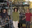 Photo of James Chou, Daniel Felantro and Hugues de Riedmatten in their entanglement lab at Caltech.