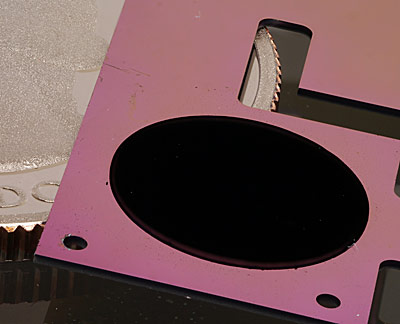 The circular patch of carbon nanotubes on a pink silicon backing is one component of NIST’s new cryogenic radiometer, shown with a quarter for scale.