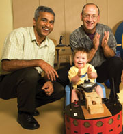 Photo of Sunil Agrawal and Cole Galloway guiding a child using a robotic car.