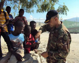 Captain Belardo performing needs assessment with Haitian children.