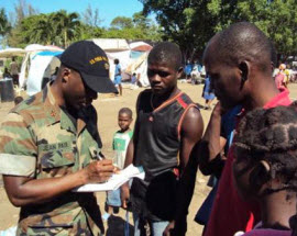 Lieutenant Commander Jean Paul gathering intelligence from young Haitian men.